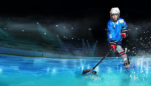 Liikkuva nuori pelaa jääkiekkoa sinisessä peliasussa jäähallissa